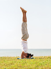 Image showing man making yoga exercises outdoors