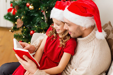 Image showing smiling father and daughter reading book