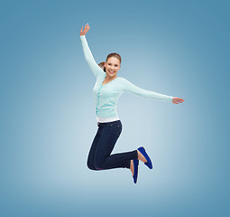 Image showing smiling young woman jumping in air