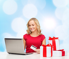 Image showing smiling woman with credit card and laptop