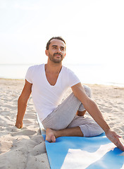 Image showing man doing yoga exercises outdoors