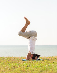 Image showing man making yoga exercises outdoors