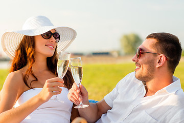 Image showing smiling couple drinking champagne on picnic