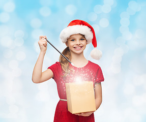 Image showing smiling girl in santa helper hat with gift box