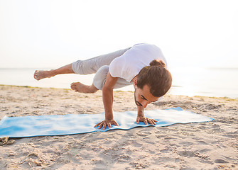 Image showing man doing yoga exercises outdoors