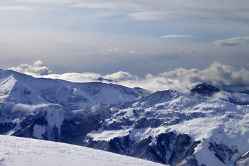 Image showing Winter mountains in clouds and ski slope