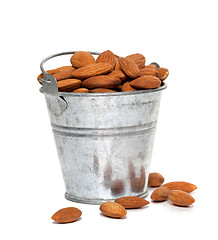 Image showing Tin bucket full of almonds on white background