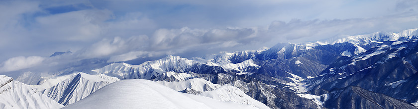 Image showing Panorama of off-piste snowy slope and cloudy mountains