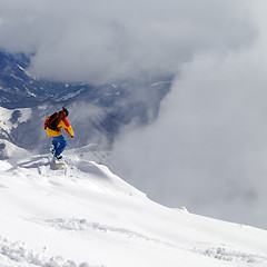 Image showing Snowboarder on off-piste slope an mountains in mist