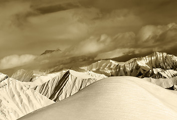 Image showing Sepia off-piste snowy slope and cloudy mountains