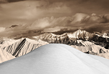 Image showing Top of off-piste snowy slope and sepia mountains