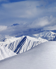 Image showing Top of off-piste snowy slope and cloud mountains