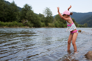 Image showing Girl throwing stone