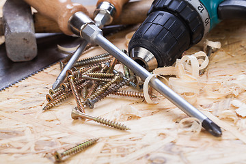 Image showing Drill with timber, screwdrivers and screws