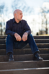 Image showing Thoughtful man sitting on a flight of steps