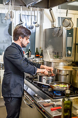 Image showing Chef cooking a vegetables stir fry over a hob