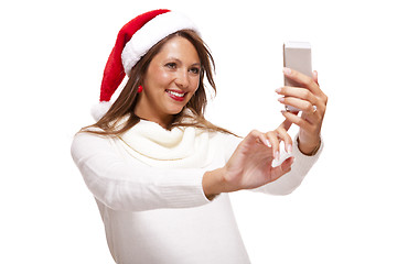 Image showing Pretty woman in a Santa hat reading an sms