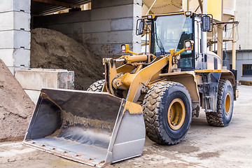 Image showing Parked pay loader near pile of dirt