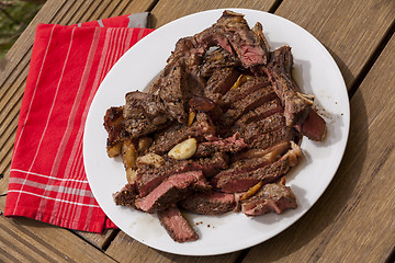 Image showing Plate of Grilled Steak and Garlic with Red Napkin