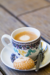 Image showing Cup of freshly brewed tea and a cookie