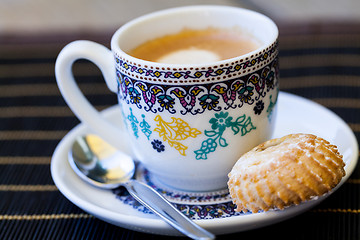 Image showing Cup of freshly brewed tea and a cookie