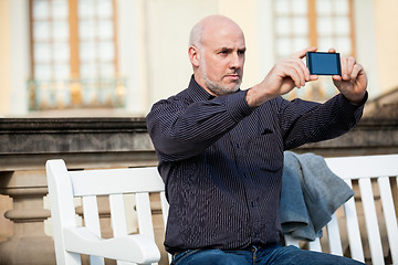 Image showing Man taking a photograph with his mobile