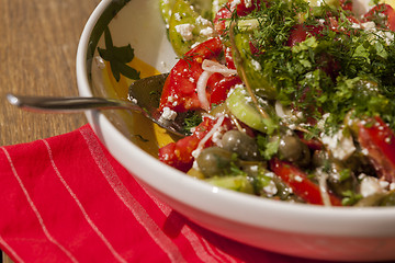 Image showing Bowl of Marinated Greek Salad with Red Napkin