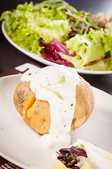 Image showing Baked jacket potato with sour cream sauce