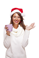 Image showing Cold young woman in a Santa hat sipping coffee tea