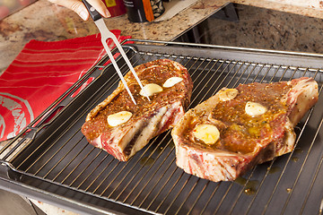 Image showing Two Steaks Marinated with Oil and Garlic on Grill