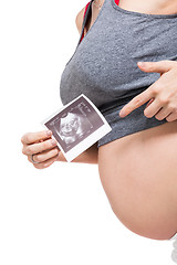 Image showing Pregnant woman displaying a prenatal ultrasound