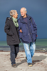 Image showing happy elderly senior couple walking on beach