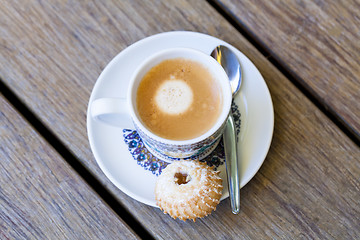 Image showing Cup of freshly brewed tea and a cookie