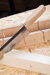 Image showing Hand saw cutting through a beam of wood