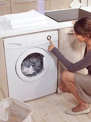 Image showing pretty smiling girl in the laundry room lhn