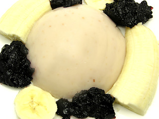 Image showing Almond pudding with banana and blueberry jam on a white plate