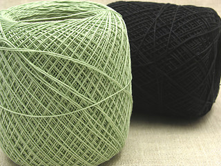 Image showing Two balls of wool  lying and standing on a beige background