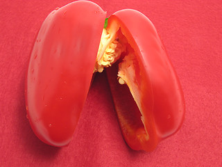 Image showing Red pepper cutted into halves on a red placemat