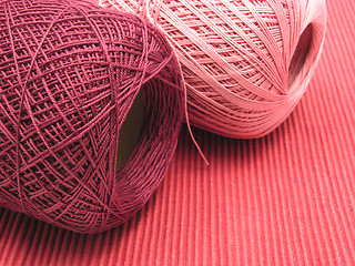 Image showing Two balls of wool  on a red background