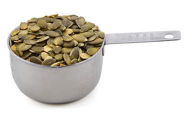 Image showing Green pumpkin seeds in a cup measure