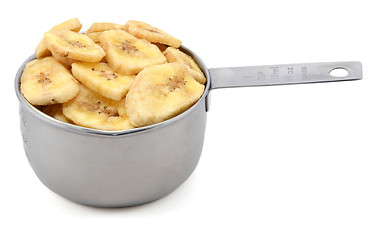 Image showing Dried banana chips in a cup measure