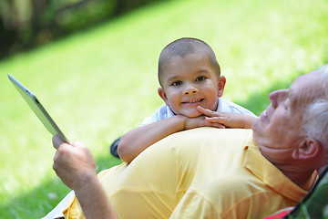 Image showing grandfather and child in park using tablet