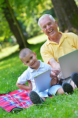 Image showing grandfather and child using laptop