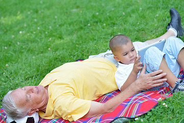 Image showing grandfather and child in park using tablet