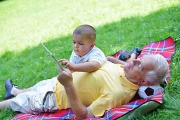 Image showing grandfather and child in park using tablet