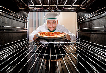 Image showing Chef cooking pizza in the oven.