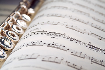 Image showing A flute rests inside a musical score