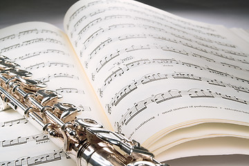 Image showing Flute on an open musical score with gray background
