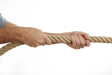 Image showing Man in a blue shirt pulls a rope