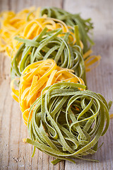 Image showing yellow and green uncooked pasta tagliatelle 